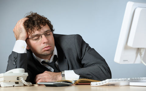 man wearing suit falling asleep in front of his computer