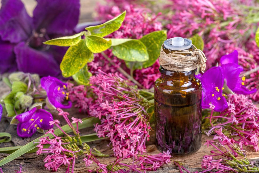 bottle of clary sage essential oil surrounded by flowers