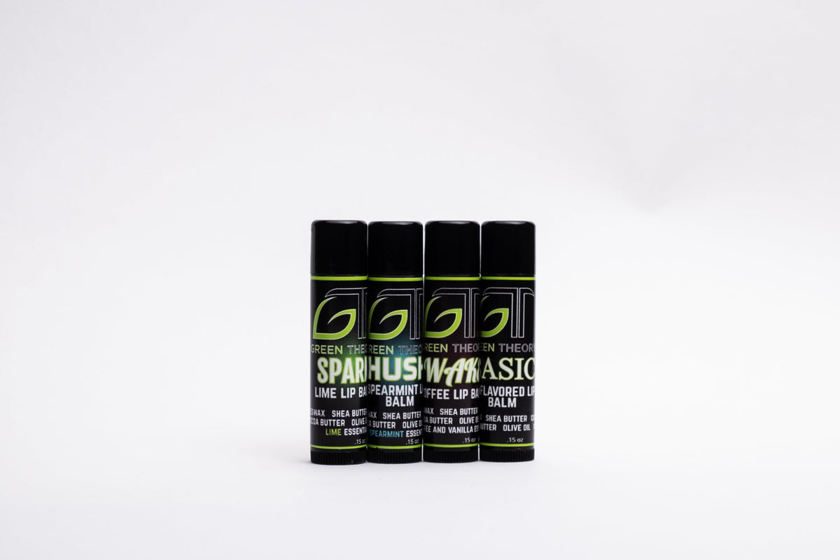 Four Green Theory Naturals natural lip balms lined up on white