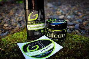 Green Theory Thunderstruck deodorant, Vulcan hair clay and Green Theory logo sticker on mossy rock