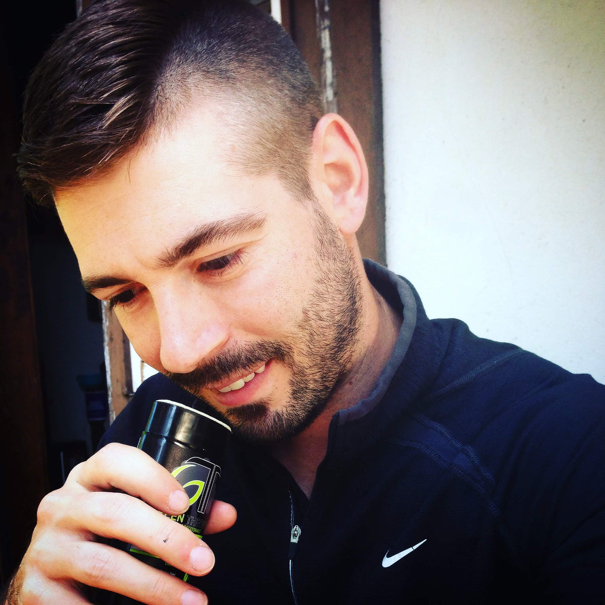 image of green theory naturals owner and ceo, Tim Schley smiling and smelling a stick of green theory natural aluminum free deodorant