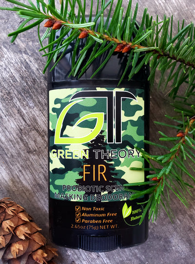 Green Theory Fir probiotic deodorant front laying on a wood texture with fir cone and needles