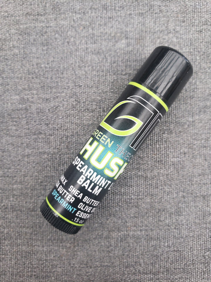 green theory Hush all natural lip balm photographed laying down at an angle against a grey felt background