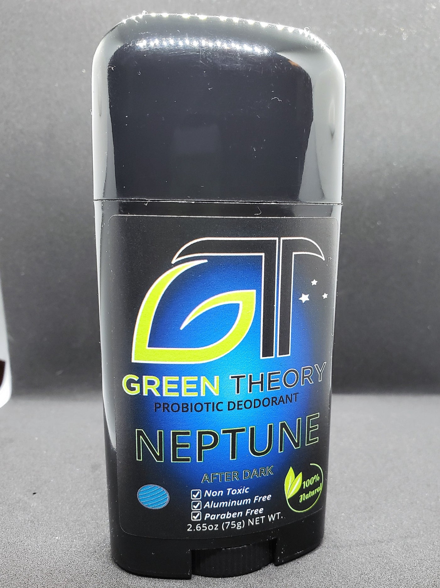 photo of green theory Neptune probiotic aluminum free natural deodorant for men. Stick is propped standing at a rotated angle against a black foam background