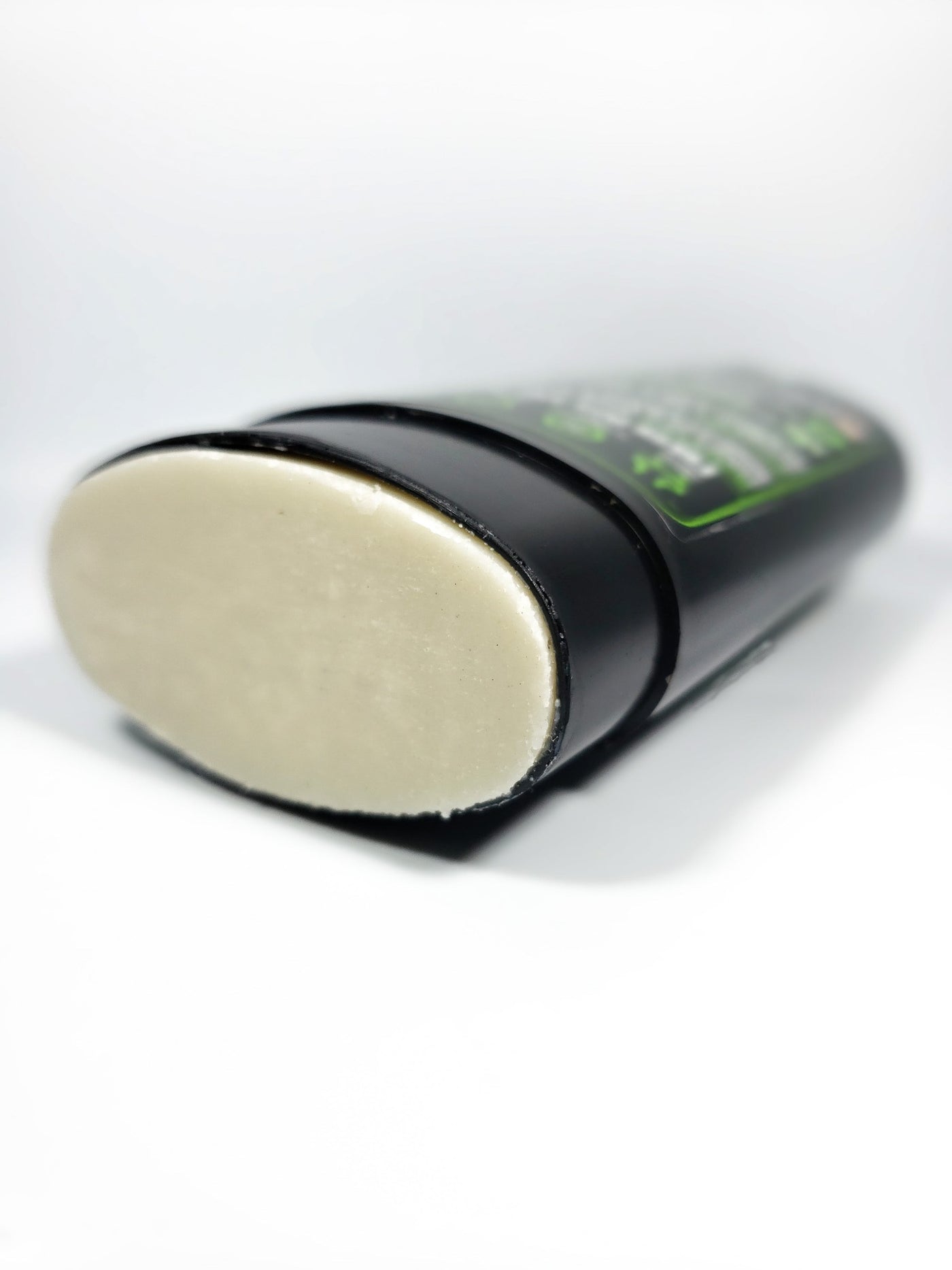 photo of deodorant laying on its back with the cap off depicting the texture of green theory kama natural probiotic deodorant.