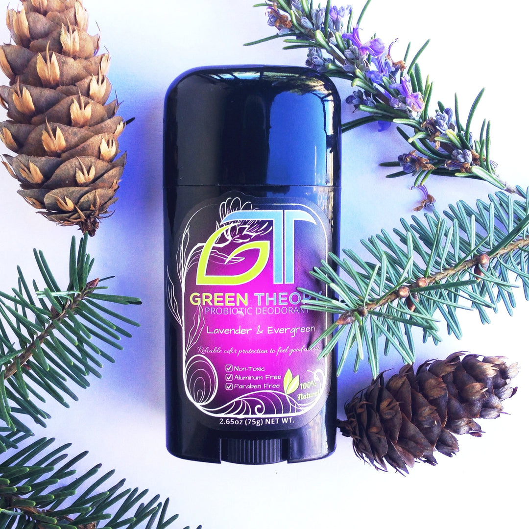 Lavender &amp; Evergreen Probiotic Deodorant laying on a white background with pine cones , pine needles and lavender surrounding the container