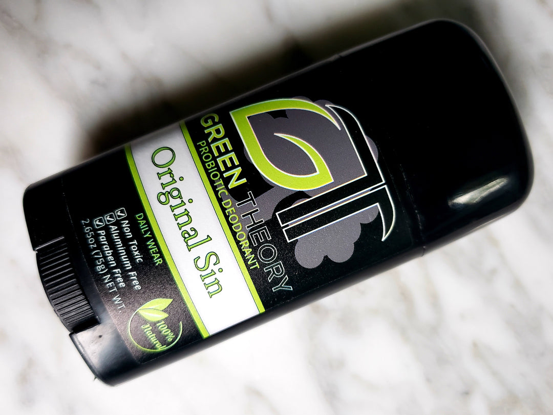 stick of green theory original sin aluminum free deodorant for men laying on marble background