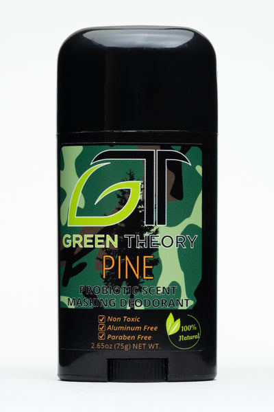 photo of the front of a stick of green theory Pine probiotic aluminum free deodorant. Product container is a sleek black plastic material. It is against a pure white background. The front label is an older, army style looking green, brown, black camouflage. The green theory GT logo is large at the top of the label with the G in the shape of a leaf. "Pine" is written in blaze orange with "probiotic scent masking deodorant" below and "non toxic", "aluminum free", and "paraben free" listed as product benefits.